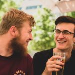 two men smiling with alcohol