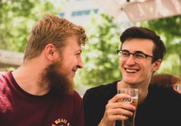 two men smiling with alcohol