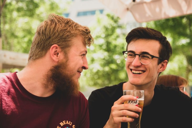 two men smiling with alcohol